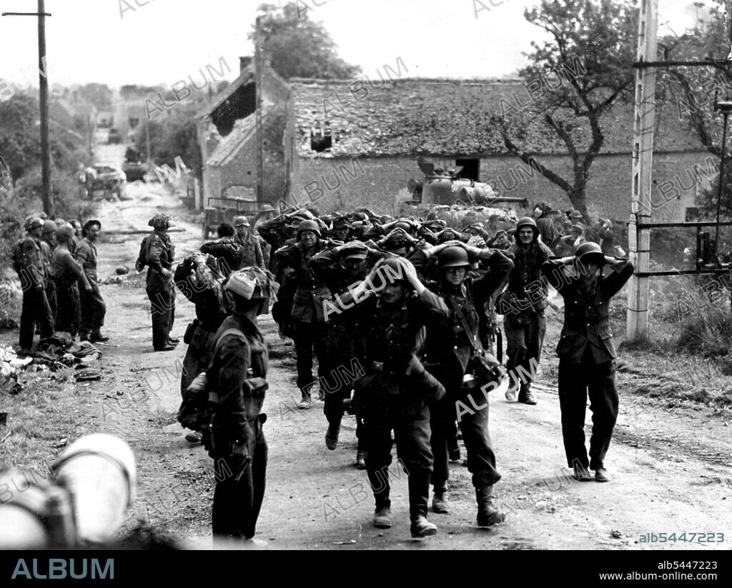 Show Your Hands Jerry! With the Nazi violating the white flag of surrender during the Italian campaign, these Canadians in France are taking no chances and compel German prisoners to show their hands. Here are a column of them marching back from St. Lambert-Sur-Dives. October 23, 1944. (Photo by Canadian Army - W. I. B).