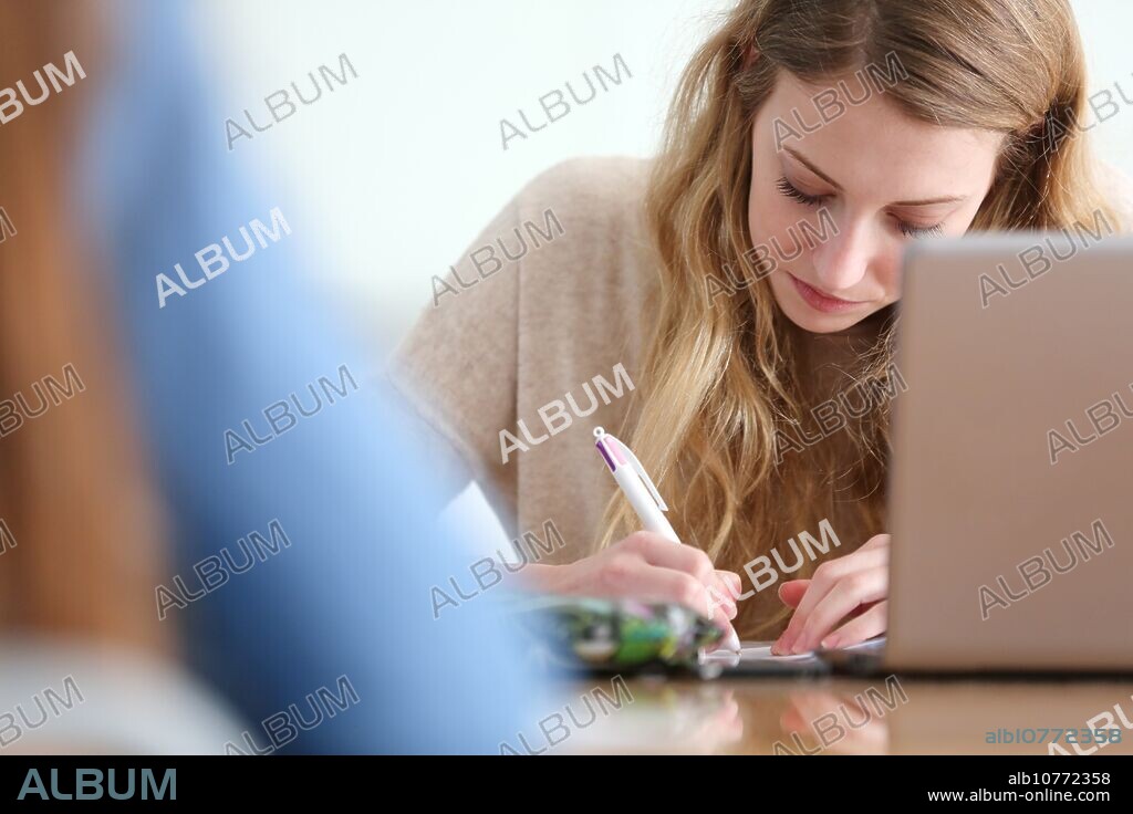 Young female student with laptop at campus.