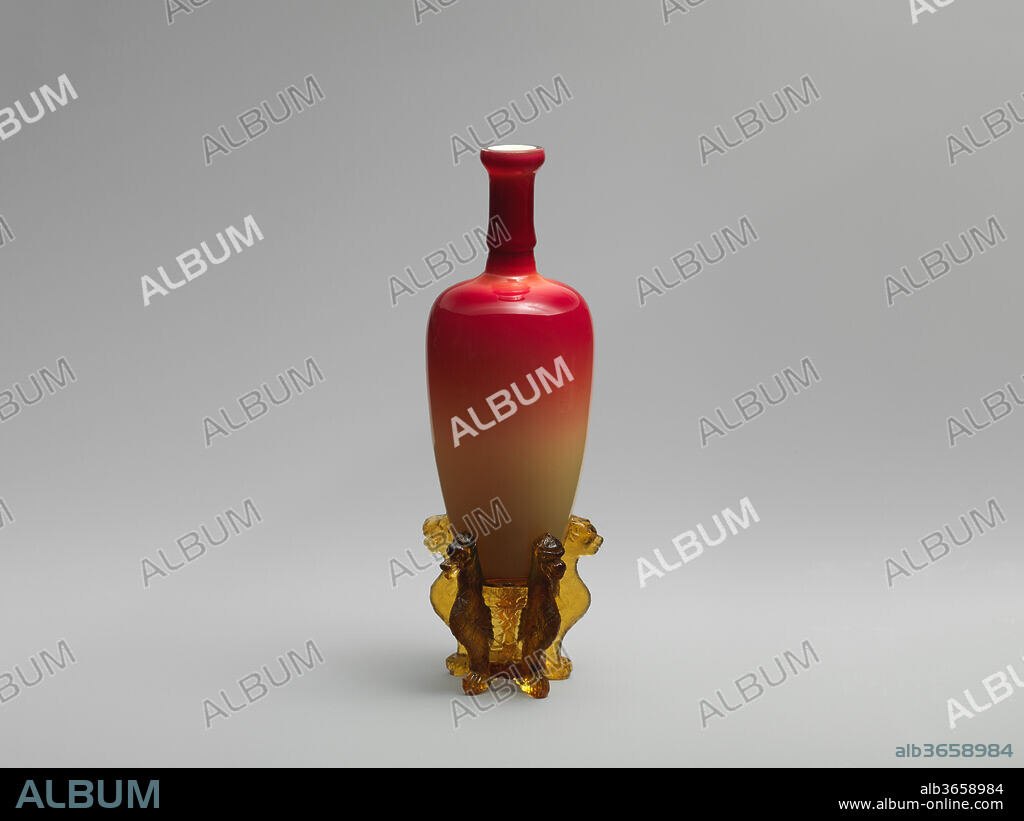 "Morgan Vase" and stand. Culture: American. Dimensions: Height: 10 in. (25.4 cm). Manufacturer: Hobbs, Brockunier and Company (1863-1891). Date: 1886-91.
The second half of the nineteenth century witnessed a proliferation of highly ornamental decorative arts in nearly every medium. Glassmakers during this period experimented with new techniques, introducing bold color effects and embracing exotic influences. Many new lines of art glass imitated other materials. This particular form was made in imitation of the "Morgan Vase," the famous eighteenth-century Chinese porcelain vase with a peachblow glaze from the collection of Mrs. Mary Morgan, which sold at auction in 1886 for the astonishing price of $18,000. Hobbs, Brockunier & Company was one of a number of glass firms to capitalize on this event and the company created a copy of the vase with their perfected Amberina glass, relating in shape and size to the Chinese porcelain example. The amber pressed glass base on which this vase sits imitates the carved wood base of the original.