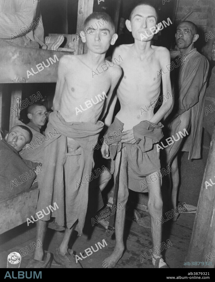 May 4, 1945 - Men suffering from starvation standing by bunks in a Nazi concentration camp, Ampfing, Germany.