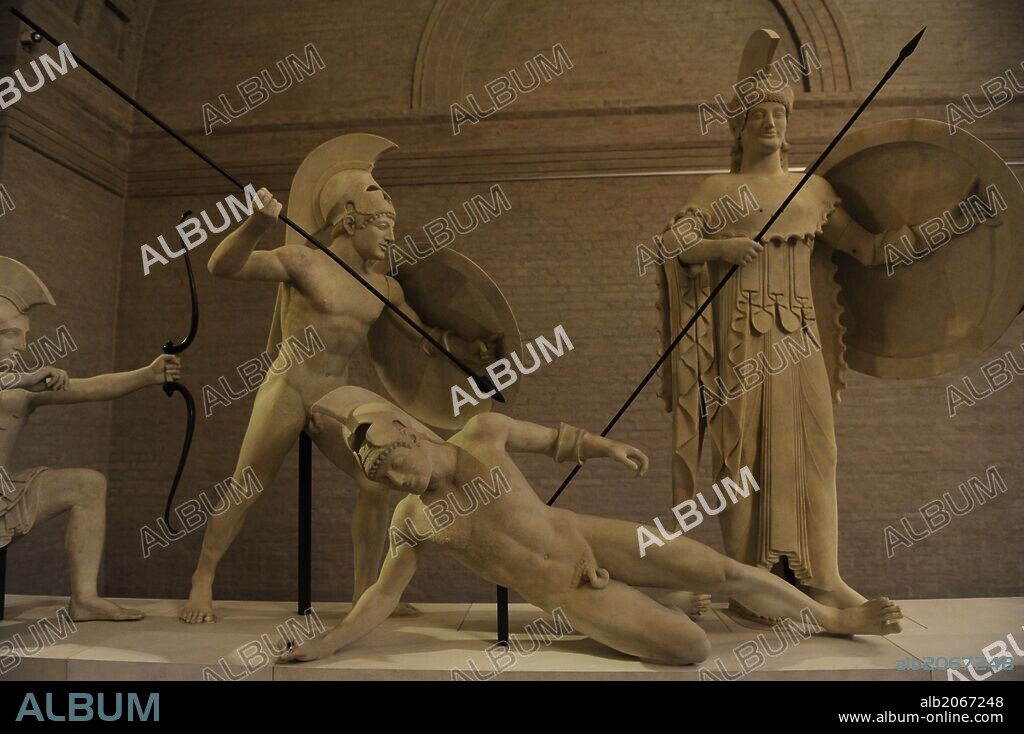 ARTE GRIEGO. GRECIA. Reconstrucción del grupo escultórico del frontón Oeste del Templo de Aegina. El original fechado hacia el 500 a. C. Guerreros troyanos y griegos junto a la diosa Atenea. Glyptothek. Munich. Alemania. Europa.