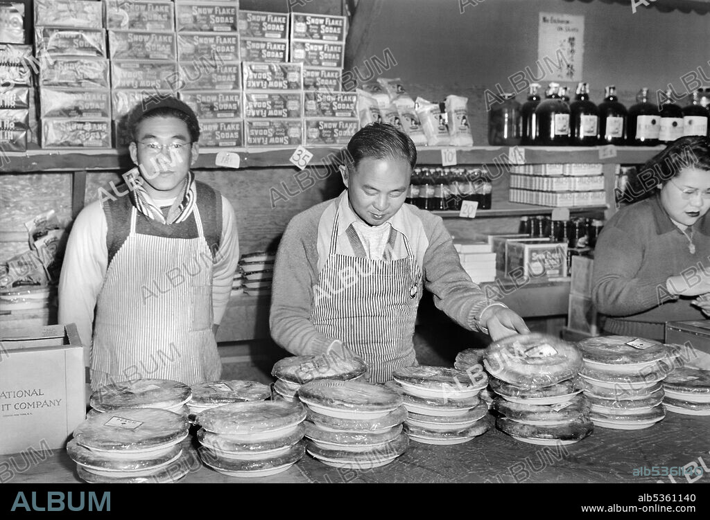 Workers standing behind Counter at Co-op Store, Manzanar Relocation Center, California, USA, Ansel Adams, Manzanar War Relocation Center Collection, 1943.