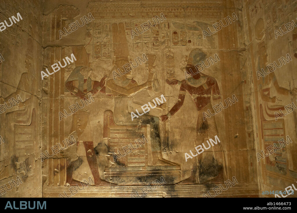ARTE EGIPCIO. EGIPTO. TEMPLO DE SETI I en ABIDOS (ABYDOS). Mandado construir por el faraón de la Dinastía XIX del Imperio Nuevo, y terminado por su hijo Ramses II. Relieve con restos de policromía original con la representación de SETI I ante la diosa Isis y el dios Horus. Abidos. Egipto. Norte de Africa.