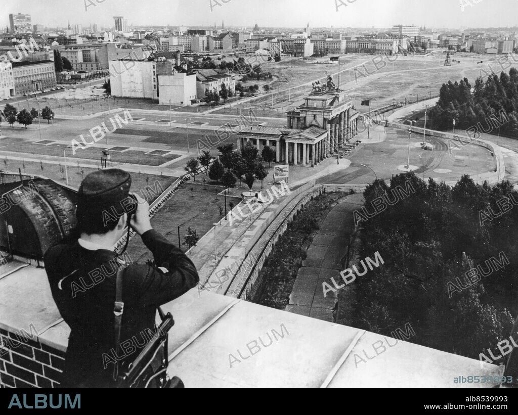 Orig. bildtext... 13. August 1969! Der Todesstreifen quer durch Berlin. Unser Foto entstand mit Blick auf das Brandenburger Tor, das durch die Sperrmauer vom Westen aus Lehnartz Anm. Brandenburger Tor, den viktigaste stadsporten i 1700-talets Berlin, på vägen från slottet och Unter den Linden ut genom Tiergarten och vidare mot det preussiska kungadömets stamland Brandenburg Kikare Utsikt sites: BERLIN;TYSKLAND.