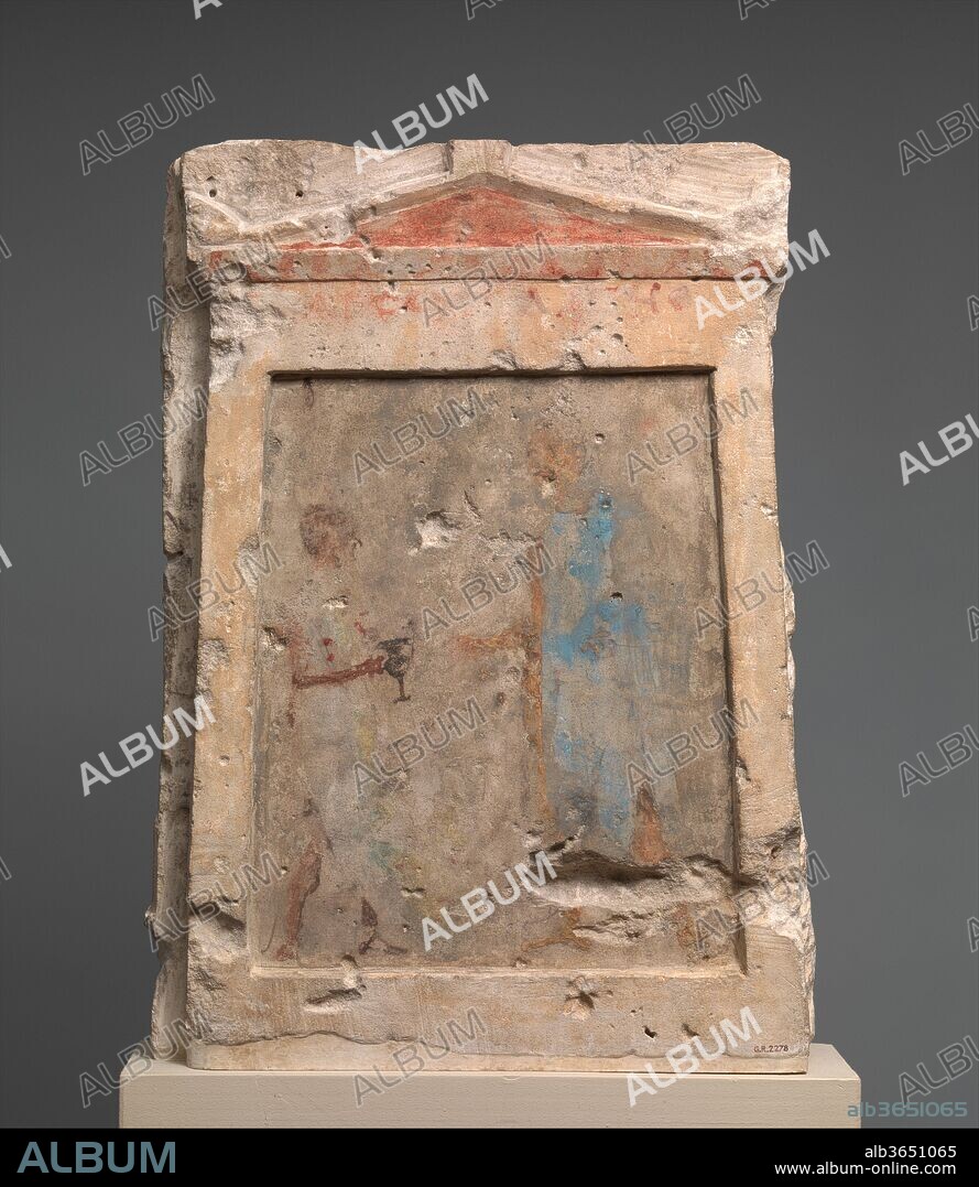Painted limestone funerary slab with a soldier taking a kantharos from his attendant. Culture: Greek. Dimensions: Other: 14 13/16 × 9 5/8 × 3 3/8 in. (37.6 × 24.4 × 8.6 cm)
Other (Panel): 9 3/4 × 7 7/8 in. (24.8 × 20 cm). Date: 2nd half of 3rd century B.C..
A boy with dark brown skin, standing at the left, holds out a black cup to a tall soldier in a long blue cloak, at the right. The boy holds a lance and supports the soldier's large oval shield  against his chest.  Almost all the preserved evidence for painting in the Hellenistic period comes from funerary monuments. Some like the vaulted tombs of Macedonia and Thrace show large scale figures and friezes. More modest painted stelai like the ones displayed here have been found in many places in the Eastern Meditereanean.