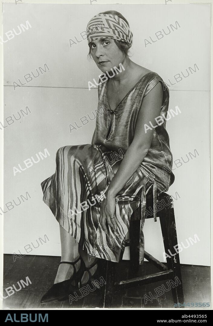 ALEXANDER MIKHAILOVICH RODCHENKO. Portrait of Lilya Brik (1891-1978) in golden robe. The scarf designed by Lyubov Popova.