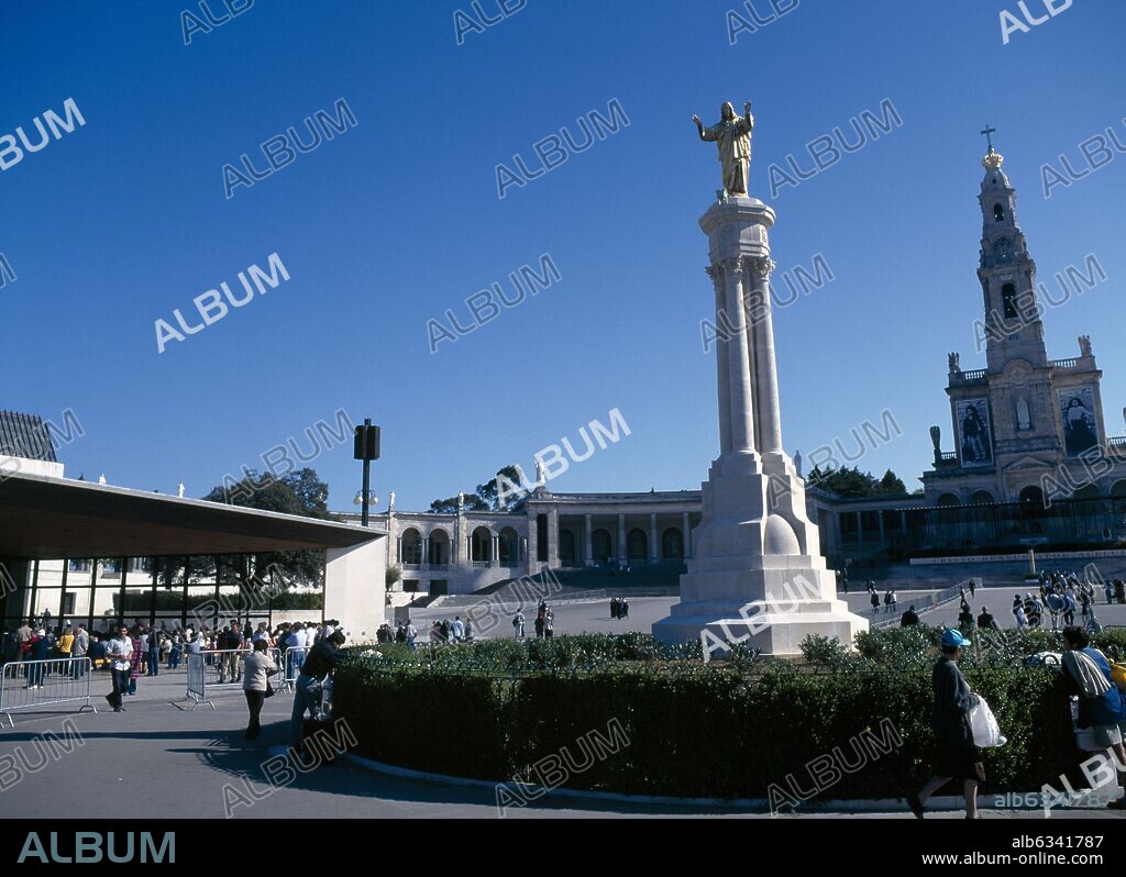 Portugal, Beira Litoral, Fatima, Golden Statue of Christ with church in the background.