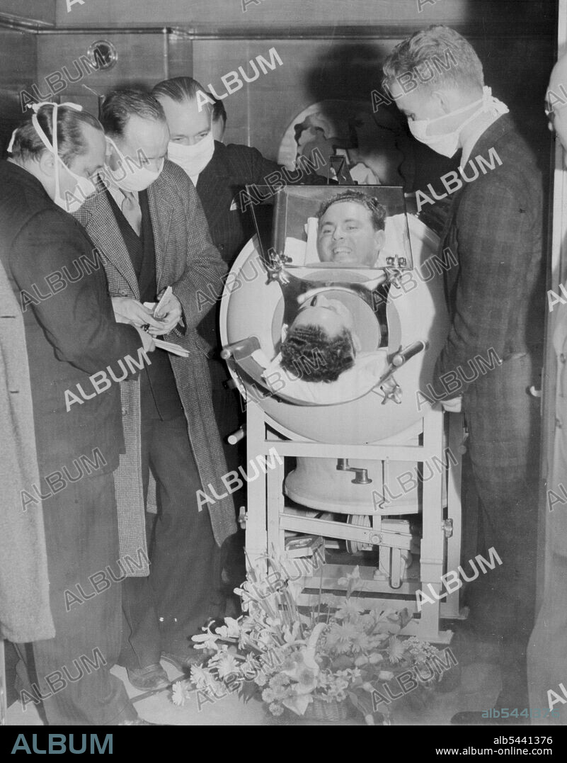 Snite Sails For Shrine Of Miracles -- From his iron lung which was been his home since 1936, 28-year-old Fred Snite, jr., infantile paralysis victim talks to reporters aboard the S.S. Normandie as he sailed from New York May 16 on a pilgrimage to Loudres, France, The Shrine of Miracles. May 16, 1939. (Photo by Associated Press Photo).