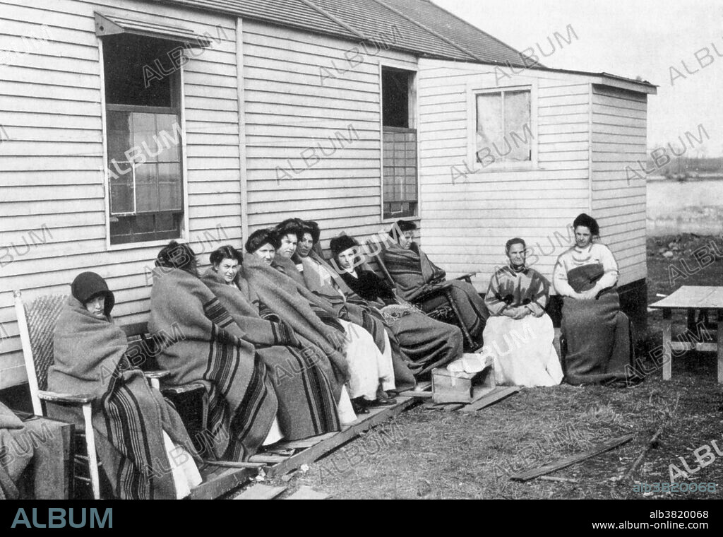 Editorial use only . Captioned: Mary Mallon, better known as Typhoid Mary, sits fourth from the right, among a group of inmates quarantined on an isolated island in the Long Island Sound. Mallon (1869-1938), better known as Typhoid Mary, was the first person in the US identified as an asymptomatic carrier of the pathogen associated with typhoid fever. From 1900 to 1907 she worked as a cook in New York and was presumed to have infected 49 people, 3 of whom died, over the course of her career. Mallon said she rarely washed her hands when cooking and felt there was no need to do so. Tests revealed that her gallbladder was teeming with typhoid salmonella. She refused to give up her occupation as a cook, maintaining that she did not carry any disease. She was forcibly isolated twice by public health authorities and died after a total of nearly three decades in isolation. Undated photograph, but Mallon was quarantined on the same island twice. First quarantine 1907-1910.