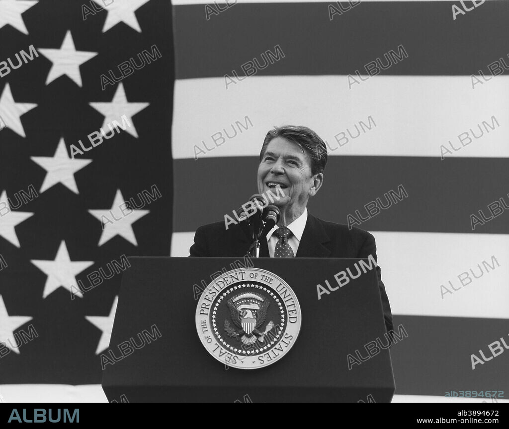 President Ronald Reagan speaking in front of a large American Flag.