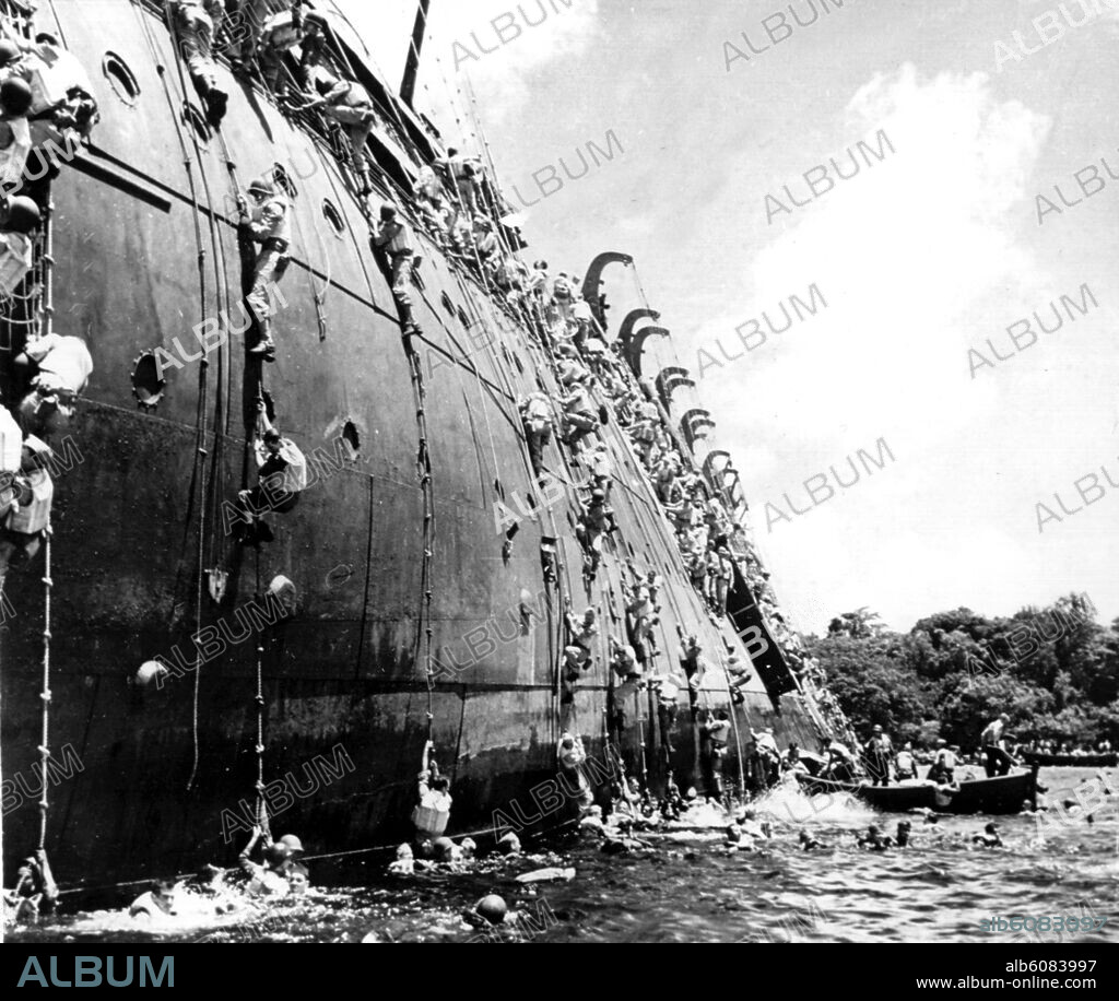 Amerikanische Soldaten seilen sich von Bord des Truppentransporters USS Präsident Coolidge ab, nachdem das Schiff im Dezember 1942 bei einer kleinen Pazifikinsel auf eine Mine aufgelaufen war. Das Schiff sank, von den rund 4000 Menschen an Bord starben zwei. 30/11/1942