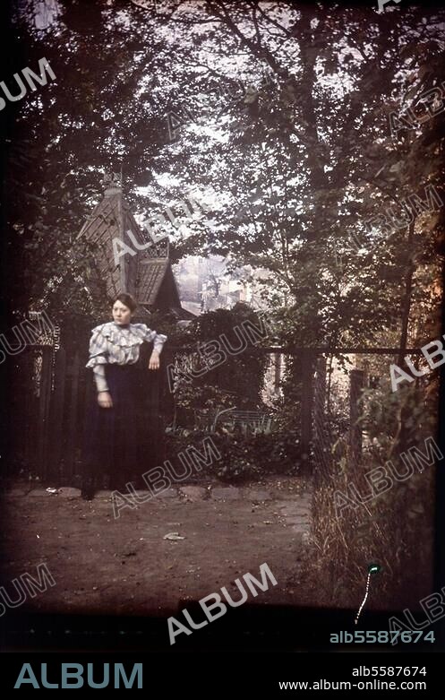 People in the park. Young lady in the park of the Château des Brouillards in Montmartre in Paris; View towards the Rue de l'Abreuvoir. Amateur photo (autochrome), anonymous, c. 1910. Berlin, Sammlung Archiv für Kunst und Geschichte.