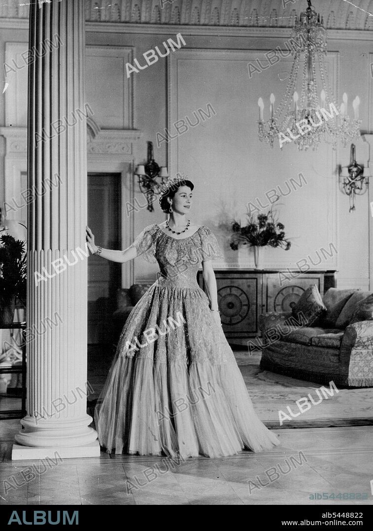 The Queen At Clarence House - This Royal Command Portrait Study by Baron shows her Majesty Queen Elizabeth in the drawing room of Clarence House, London. Queen Elizabeth is wearing a lace ball dress of smoke grey tulle neddlerun with silver thread. Her Sapphire and Diamond Necklace was a Wedding present from her father the late King George VI. Her Tiara was a wedding gift from Queen Mary. Her Diamond Bracelet was a wedding present from her husband, Prince Philip the Duke of Edinburgh. June 1, 1952. (Photo by Associated Press Photo).