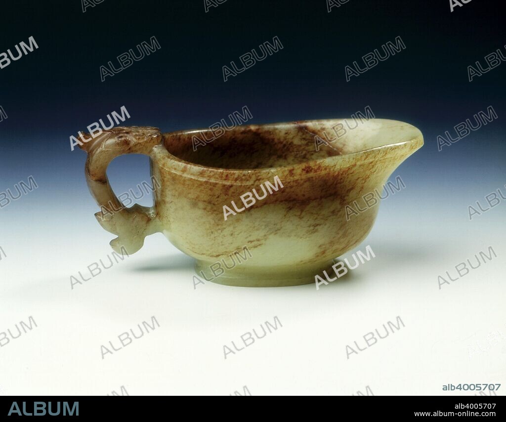Jade vessel with kui dragon handle, Song dynasty, China, 960-1279. A small plain jade vessel of Yi-form with thickened rim. The shape of this archaistic vessel is derived from the bronze Yi-shaped pouring vessels of the Zhou dynasty. The piece is of pale celadon colour with extensive brown flecking.