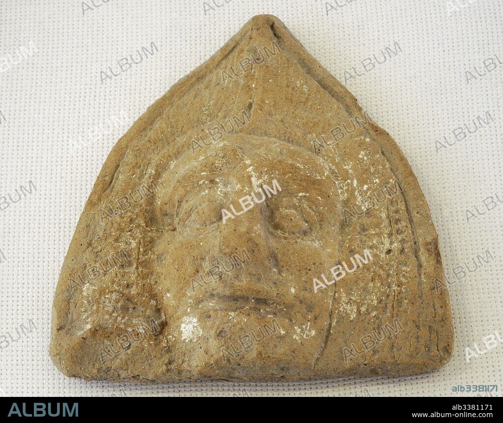 Antefija romana. Epoca altoimerial. Representa una cabeza masculina, cubierta con una especia de capucha (cucullus). Museo Nacional Arqueológico. Tarragona, Cataluña, España. Roman antefix. Vertical block which terminates the covering tiles of the roof. High-imperial era. Roman antefix. High-imperial era. Male head, covered by a cucullus. National Archaeological Museum. Tarragona. Catalonia, Spain.