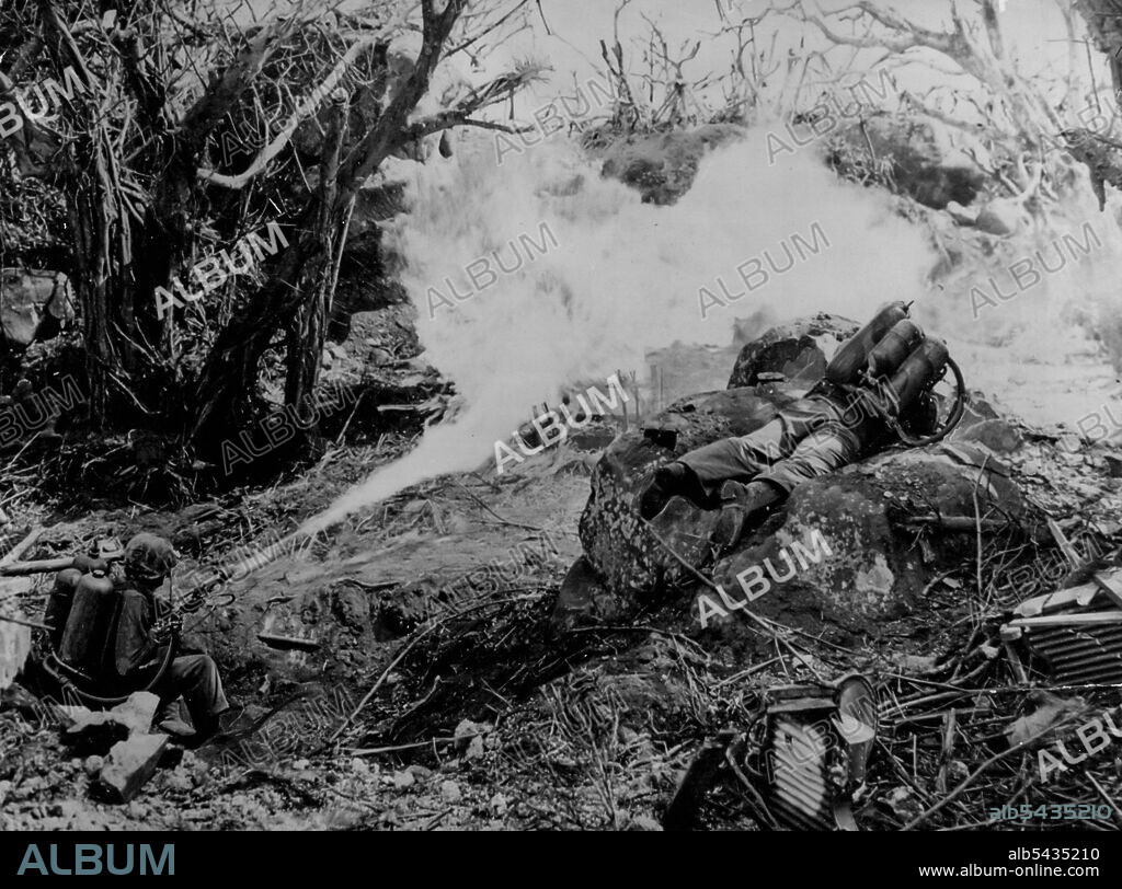 Devil's Breath On Hell's Island -- Two Marine privates hit the deck to throw a scorching inferno at the mighty defenses which blocked the way to Iwo Jima's Mount Suribachi. Left to right: Private Richard Klatt, of North Fond Dulac, Wis., and Private First Class Wilfred Voegeli (whose home town was not given). March 14, 1945. (Photo by Official U.S. Marine Corps Photo).