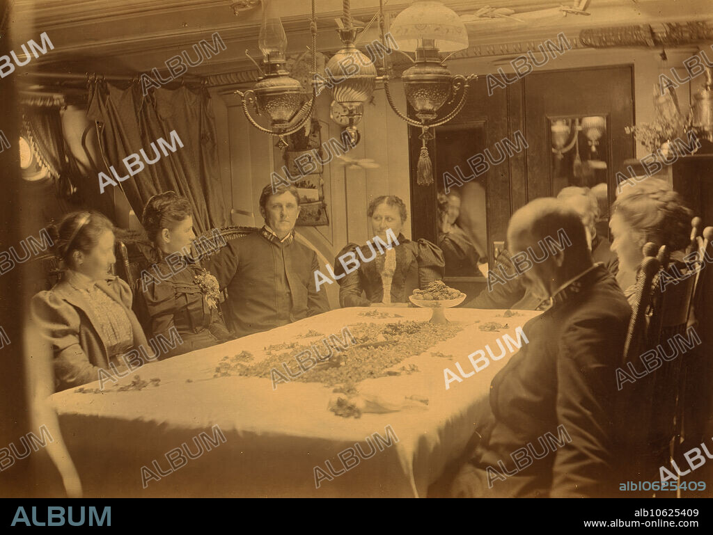 ALFRED LEE BROADBENT. Captains, their wives, and two female tourists sitting around a table aboard ship, Dutch Harbor, Alaska, (1897?)..