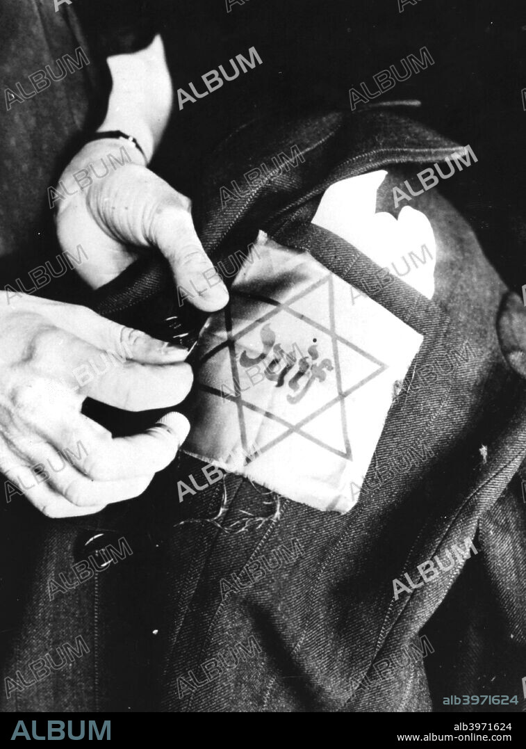 Sewing the yellow star identifying a Jew onto a jacket, German-occupied Paris, 1942. Life for French Jews became increasingly oppressive under Nazi occupation. Collaborators in both the occupied part of the country and the area controlled by the Vichy regime co-operated enthusiastically in the persecution. The Jewish population were compelled to wear the yellow star on their clothing from 1941. In 1942-1944 some 76,000 Jews were deported to concentration camps. Only 2500 survived.