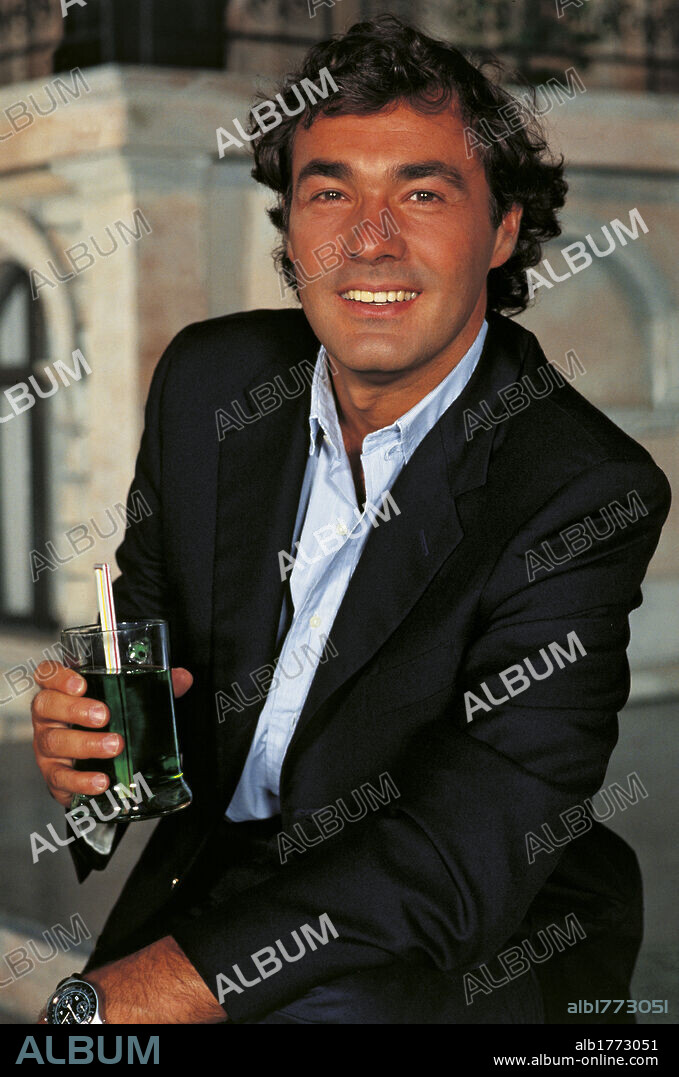 Massimo Giletti smiling holding a glass. Italian TV presenter and journalist Massimo Giletti smiling and holding a soft drink. 1990s.