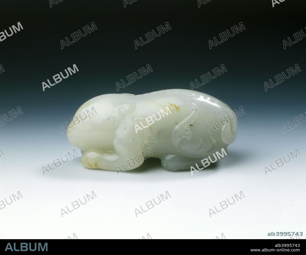 White jade mythical animal, Yuan dynasty-early Ming dynasty, China, 1279-1499. A jade mythical animal, or possibly a stylised rabbit. Its back shows pronounced vertebrae and its stomach underside is ridged. Its hocks have flaming extenuations. The tail is bi-forked with bushy tail in centre curling to one side. The ears are small and cornucopia shaped, the claws well-carved and accentuated by double line. The rear legs are large in proportion.