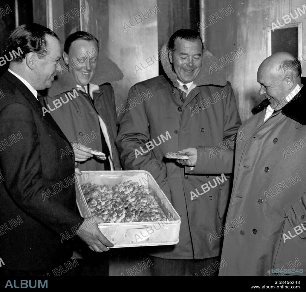 Enskede 1953-03-30. Invigningen av nytt fryshus i Enskede. Källarmästare Helge Lund bjuder prins Bertil på djupfrysta wienerbröd. T. v. om prinsen Tore Lauritzon och t. h. statsrådet Sam B. Norup. Foto: SvD / TT / kod 12014.