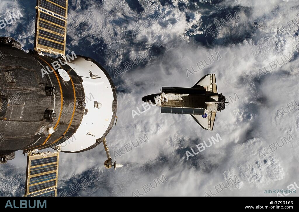 Backdropped by a cloud-covered part of Earth, Space Shuttle Atlantis was photographed by the Expedition 15 crew after it undocked from the International Space Station on June 19, 2007, in preparation for the journey home. The STS-117 astronauts completed about eight days of joint operations with the station crew. The docked Soyuz spacecraft is visible at left.