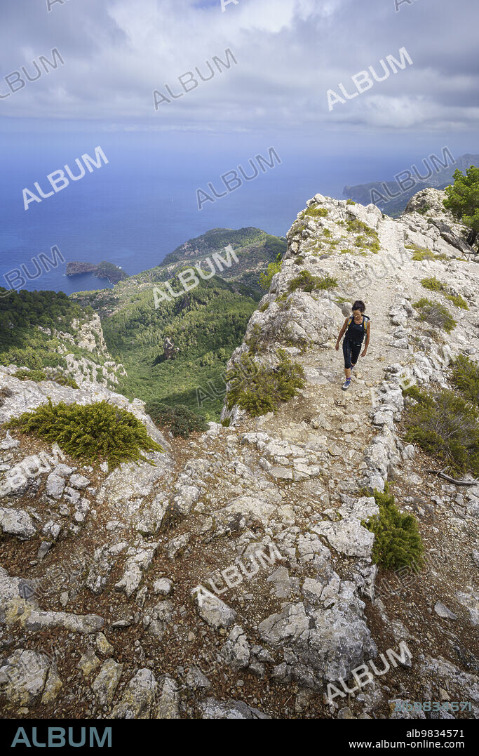 middle-aged woman walking Camí de s'Arxiduc route, Valldemossa, Majorca, Balearic Islands, Spain.