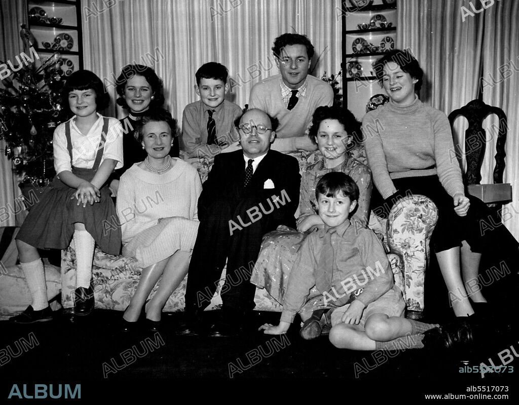Peer Has Big Family -- Home for the holidays at their home at Hurst Green, Sussex, are Lord and Lady Pakenham with seven of their eight children. They are (left to right): Catherine (nine), Antonia (23), Lady Pakenham, Michael (12), Lord Pakenham, Patrick (18), Rachel (13), Judith (15), and sitting on the floor, Kevin (eight). Lord Pakenham was First Lord of the Admiralty in Britain's last Labour (socialist) Government. December 30, 1955.