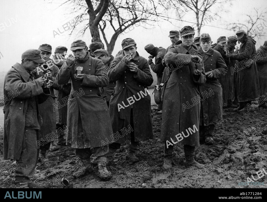 German prisoners of war eating canned food. A group of German soldiers captured in Alsace and prisoners of the Allied Seventh Army eating canned food. Alsace, November 1944.