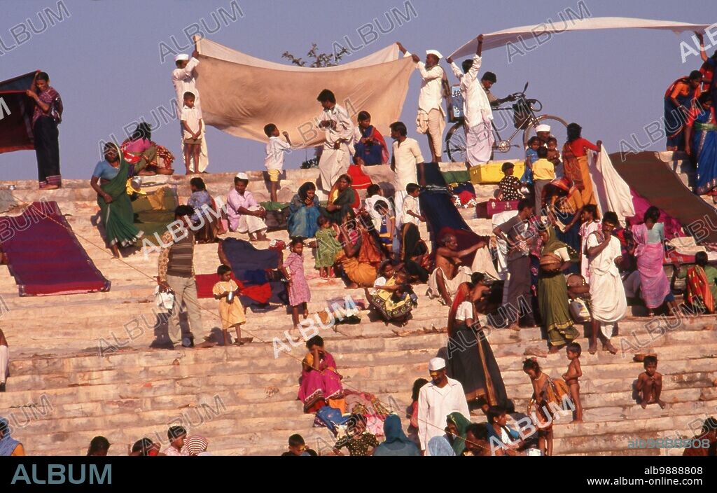 India: Pilgrims bathing at the Jogula Bhavi holy tank, Saundatti, Karnataka, during the Shri Yellamma Devi Fair (1994). Every year in the Hindu month of Magh (January - February) more than half a million people gather around the tiny temple of the goddess Yellamma in Saundatti. Yellamma is the patron of the devadasi or women dedicated to the service of a deity or temple.