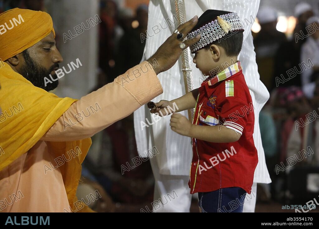 Ajmer Sharif dargah, Rajasthan. Boy receiving a blessing from Sheikh Syed Zainul Abedin Ali Khan. India.