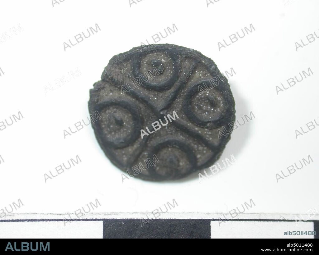 Medal, dark with golden glow (copper alloy). On the coin is the image of a cross with in every quarter a circle with a dot in it. Back is flat with a tube. Length of the tube is 0.3 cm and the diameter of the tube is 0.45 cm., Belt stroke, metal, copper alloy, Dm: 1.5 cm, D: 0.15 cm, end of the 14th century 1350-1400, Netherlands , Zeeland, Hulst, Drowned Land.
