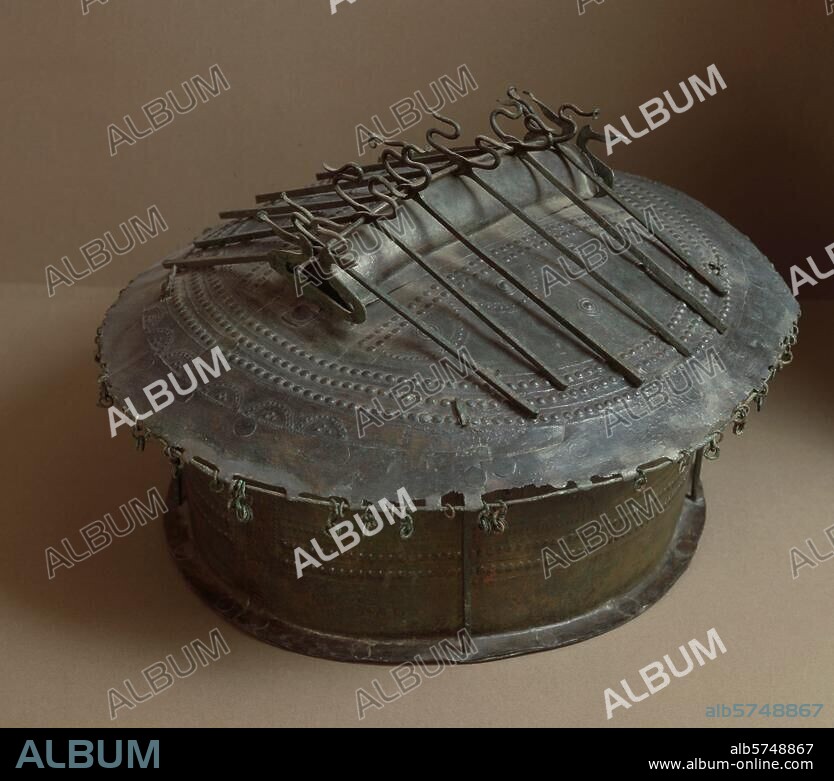 Frühetruskisch, Villanovakultur, 1. Hälfte 8. Jahrhundert v. Chr. Aschenurne in Form einer Hütte. Bronze, gewalzt und gegossen, Bleiplatte im doppelten Boden; Höhe 28,5 cm, Länge. 40,5 cm, Breite 35,7 cm. Fundort: Vulci, Osteria-Nekropole, Grab mit Steinciste (Tomba della Cista litica). Inv. Nr. 84900/01. Rom, Museo Nazionale di Villa Giulia.