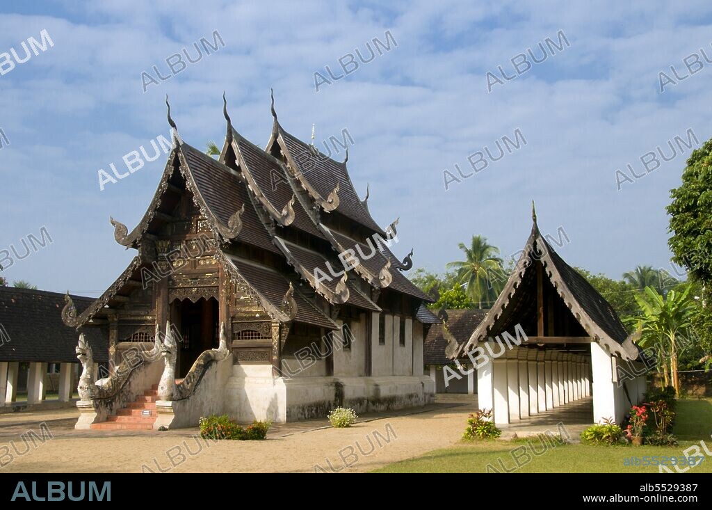Wat Ton Kwen (??? ??? ?????), more formally known as Wat Inthrawat (??? ?????????), means ‘Temple of Sugar Palms’ in kham muang or Northern Thai, and sure enough the rustic temple, set in a small village amid verdant rice paddies, is surrounded by tall and elegant sugar palms. Built at the start of the reign of Chao Kawilorot (1856-70) in 1856, Wat Ton Kwen is among the finest and purest examples surviving of traditional 19th century wooden Lan Na temple architecture. No doubt because of its small size and relative isolation, it has been spared the ‘improvements’ and other indignities suffered not just by most of its contemporary structures, but also by much older Lan Na religious buildings. The most distinctive features at Wat Ton Kwen are the typically Lan Na viharn or gabled assembly hall, and an unusual cruciform, four-porch mondop or open-sided pavilion.
