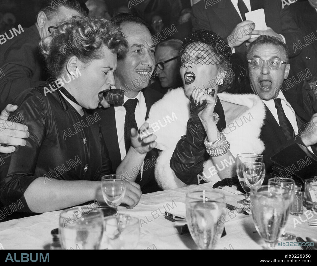 Orig. bildtext...CHEERS FOR OSCAR WINNERS NEW YORK....AT A NEW YORK NIGHT SPOT JUST AS NEWS CAME VIA RADIO FROM HOLLYWOOD OF ACADEMY AWARDS, WINNERS JUDY HOLLIDAY (LEFT) AND JOSE FERRER ARE CHEERED BY GLORIA SWANSON (RIGHT) WHO WAS A CONTENDER FOR THE COVETED AWARD. MISS HOLLIDAY WAS JUDGED THE YEAR'S BEST ACTRESS FOR HER ROLE IN BORN YESTERDAY AND FERRER'S PORTRAYAL OF CYRANO DE BERGERAC EARNED HIM THE ACADEMY AWARD AS 1950'S BEST ACTOR. GEORGE CUKOR IS SHOWN AT EXTREME RIGHT. Anm. Skådespelare Filmstjärnor Jubel Flor Leenden Armband Pälsstola Ansiktsuttryck Gapa CD282 persons: GEORGE CUKOR;GLORIA SWANSON;JOSE FERRER;JUDY HOLLIDAY sites: NEW YORK;USA.