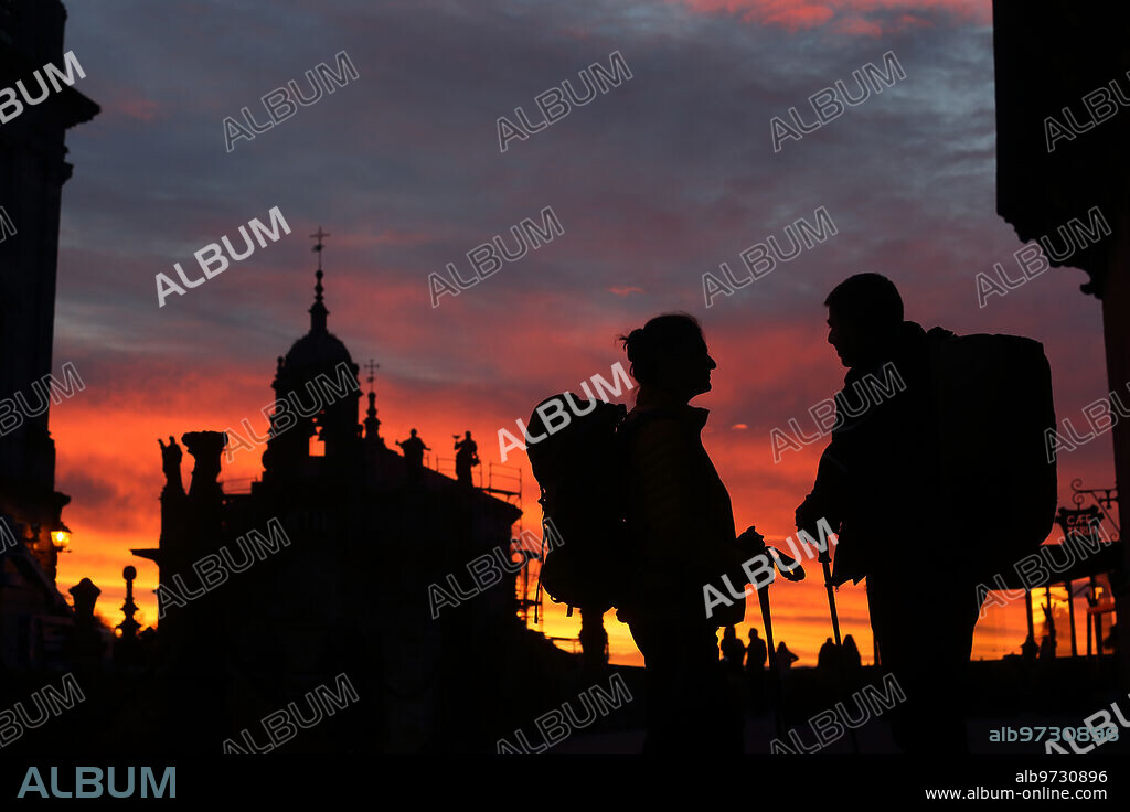Santiago de Compostela, 16/12/2021. Dos peregrinos al atardecer en la Plaza del Obradoiro. Foto: Miguel Muñiz. ARCHDC.