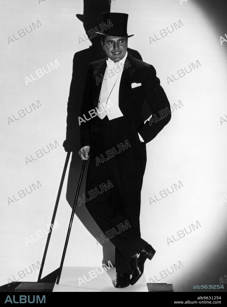 Hollywood, California, c 1930 A debonair man poses wearing a tuxedo, a top hat, and carrying a cane.