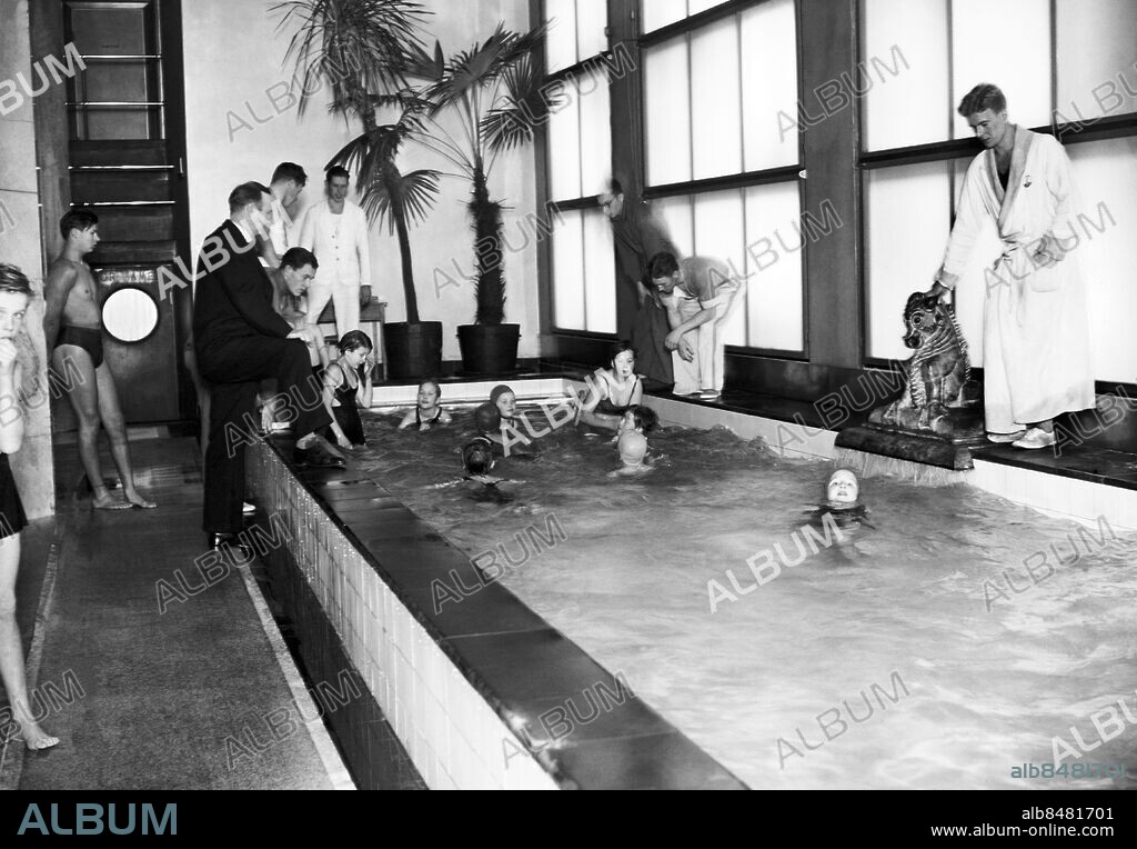 ARKIV 1936 . Simlektion i barnbassängen på Forsgrenska badet (?). Längst bort på högra sidan av bassängen syns mästersimmaren Arne Borg.. Swimming lesson in a public bath in Stockholm. World famous swimmer Arne Borg is seen the end of the right hand side of the pool. Foto: TT / Kod 1900.