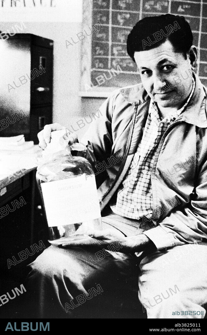 Ghiorso with a bottle of "ghiorsium", December 21, 1956. Before the retraction in 2002, the researchers from Berkeley had intended to name the element ghiorsium (Gh), after Ghiorso. No name has yet been officially suggested for the element 118 as no claims for discovery have yet been accepted by the IUPAC. Albert Ghiorso (July 15, 1915 - December 26, 2010) was an American nuclear chemist. In the early 1940s, Glenn Seaborg moved to Chicago to work on the Manhattan Project. He invited Ghiorso to join him, and for the next four years Ghiorso developed sensitive instruments for detecting the radiation associated with nuclear decay. After the war, Seaborg and Ghiorso returned to Berkeley, where they and colleagues used the 60" Crocker cyclotron to produce elements of increasing atomic number by bombarding exotic targets with helium ions. He is credited with having co-discovered the following elements: Americium, Curium, Berkelium, Californium, Einsteinium, Fermium, Mendelevium, Nobelium, Lawrencium, Rutherfordium, Dubnium, and Seaborgium. He died in 2010 at the age of 95.