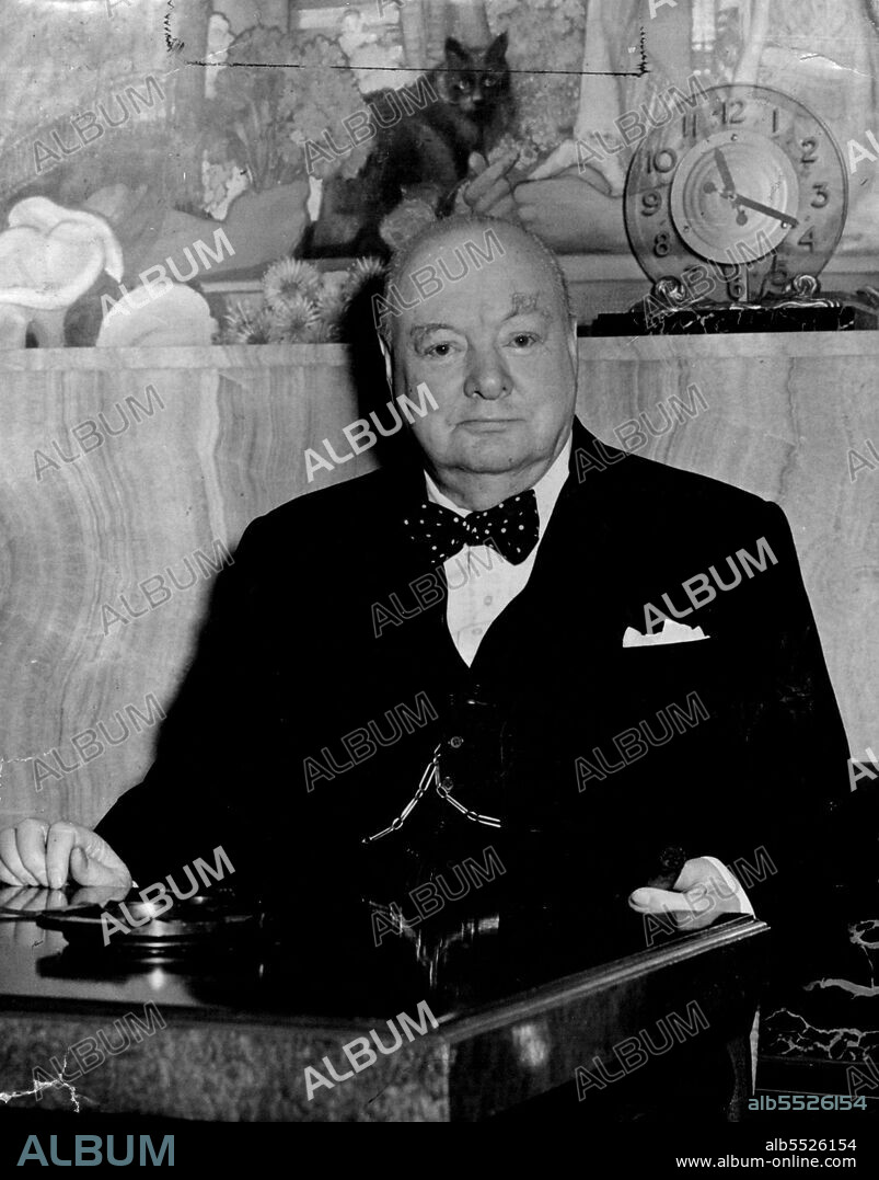 Good Luck For Churchill -- A black cat perches above the head of British Premier Winston Churchill, who wears spotted bow tie, at the Press reception aboard the cunarder 'Queen Mary' on arrival at Southampton to-day (Monday) from his talks with President Harry Truman of America.Mr. Churchill return on the ***** of Parliament's re-assembly and is expected  to take an early opportunity of telling Commons about his North American *****. January 01, 1952. (Photo by Reuterphoto).