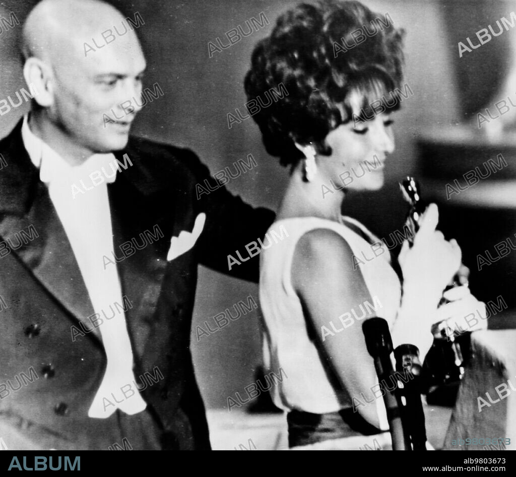 Elizabeth taylor, takes the oscar as best actress in the film BUtterfield 8, yul brynner behind her, santa monica, los angeles, california, april 18, 1961.