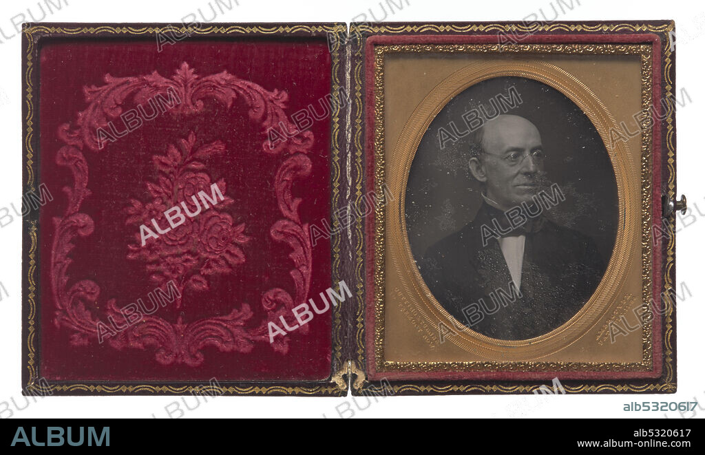 A daguerreotype of American journalist, abolitionist and editor William Lloyd Garrison in a case. In the portrait, Garrison is wearing a suit and glasses and looking off to the left. The exterior of the case is black with gold trim. The interior has embossed red velvet on the left side and the photograph inside a gold oval frame on the right. The glass over the image is heavily scratched. Stamped into the bottom left corner of the frame: "CUTTING & TURNER / 10 TREMONT ROW". And in the bottom right corner: "AMBROTYPE. / PAT. JULY. 11-54".