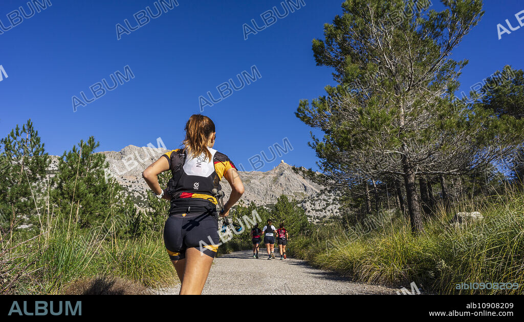 women mountain runner in front of Puig Major, Cuber reservoir, Natural area of the Serra de Tramuntana., Majorca, Balearic Islands, Spain.
