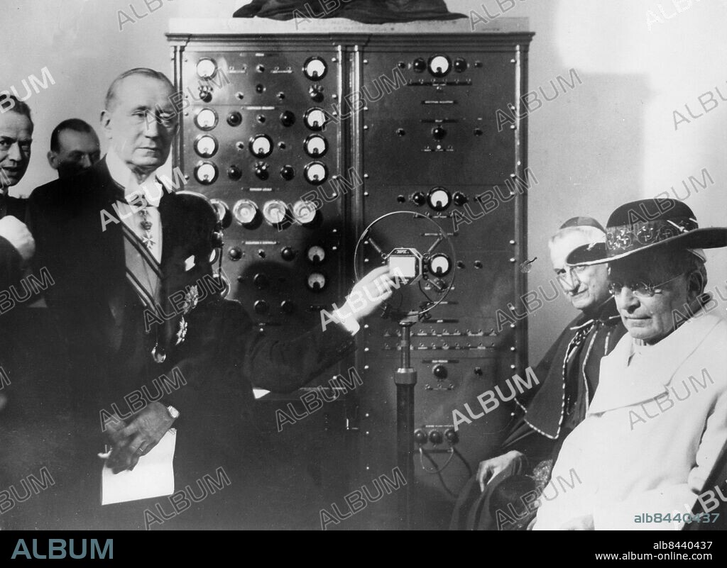 Orig. bildtext... POPE INAUGURATES MICRO WAVE RADIO TELEPHONE SERVICE BETWEEN VATICAN CITY AND ASTEL GANDOLFO PALACE - FIRST IN THE WORLD. The first regular micro wave radio telephone service in the world, between the Vatican City and Castel Gandolfo, the Pope's summer residence, was inaugurated by the Pope, in the presence of Senatore Marconi, who made the presentation of the apparatus and installation to the Pope. The ceremony was broadcast. Photo shows: The Pope (on right) listening to the address of Senatore Marconi who is standing in front of the new transmitting set, during the ceremony in the Vatican, Rome. Feb 13th 1933 Anm. CD674 persons: GUGLIELMO MARCONI;PIUS XI sites: VATIKANSTATEN.