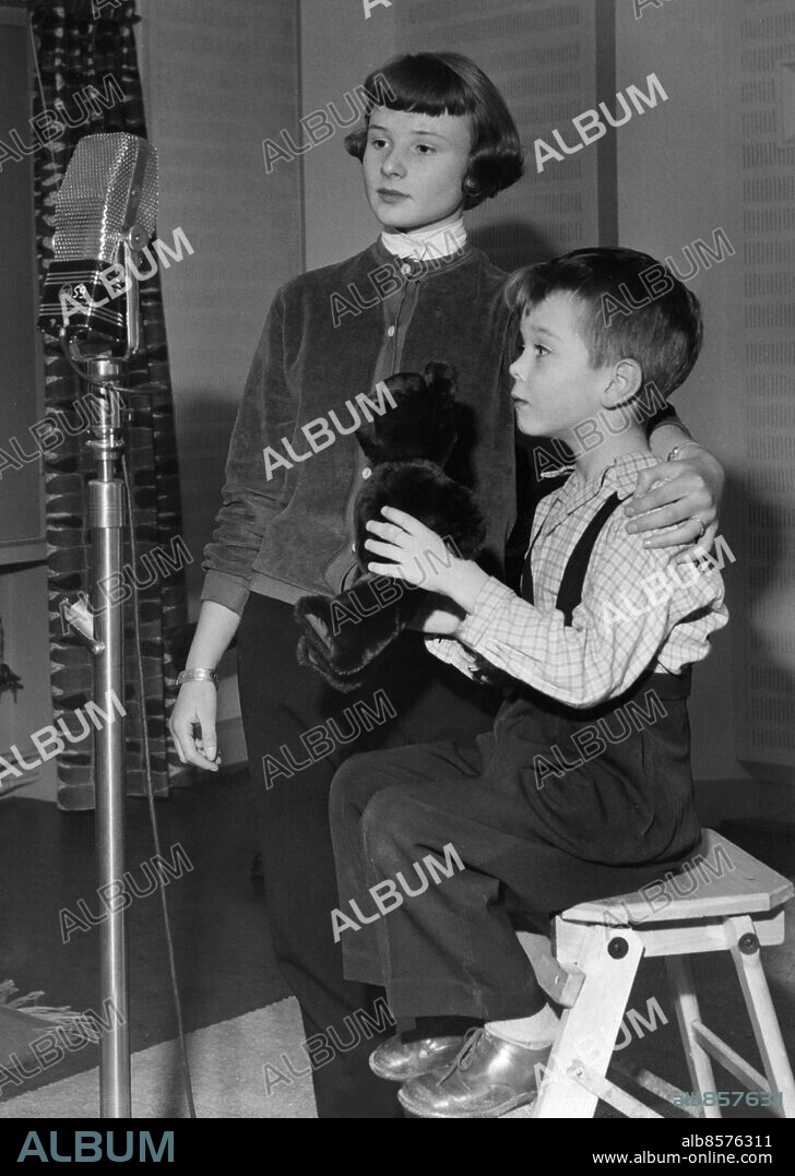 STOCKHOLM 19521127. Margareta Forsgren som Eva-Lotta och Eskil Dalenius som Rasmus i radioserien Mästerdetektiven Blomkvist, som sändes i lördagsunderhållningen Speldosan säsongen 1952-1953. Rasmus försöker lära en nallebjörn lite mikrofonteknik.. Foto: SvD / TT / Kod: 11014.