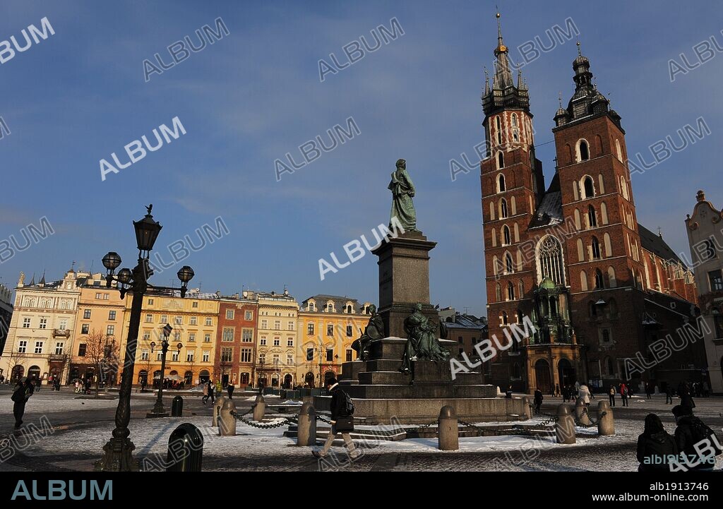 Poland. Krakow. Main Market Square. Adam Mickiewicz Monument in front of the St. Mary's Basilica, built in 14th century in Brick Gothic architecture style.