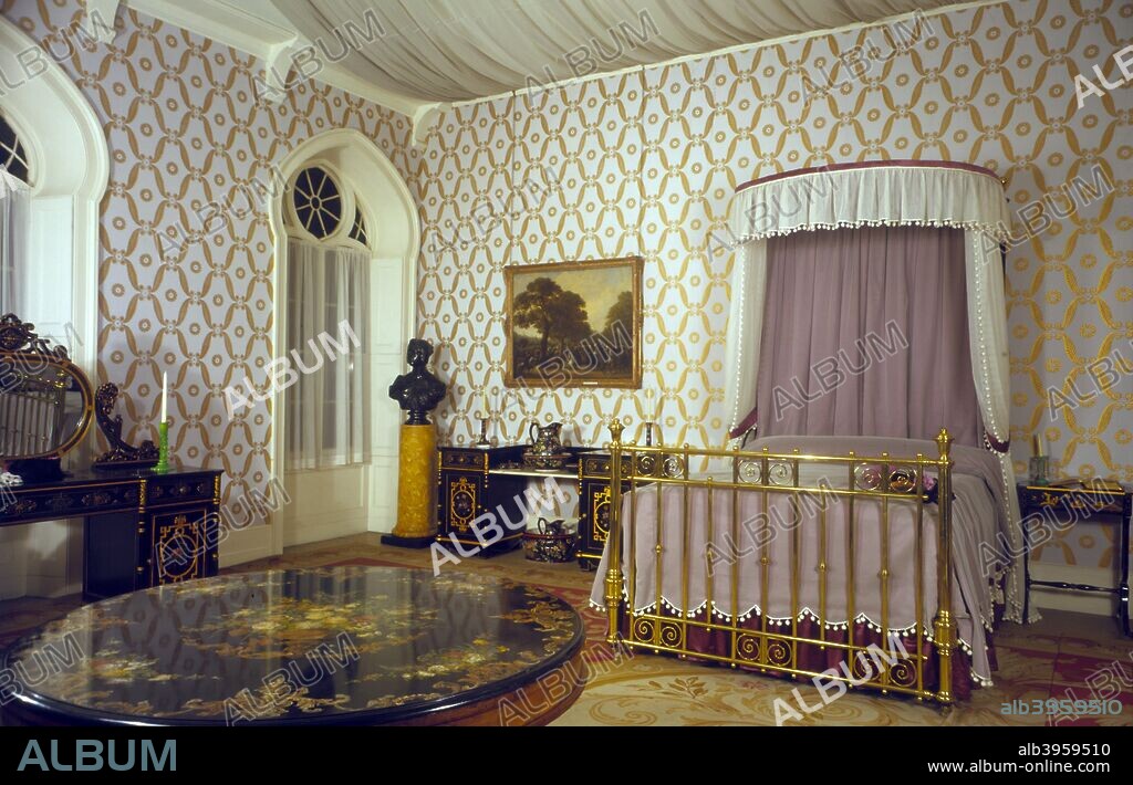 Queen Victoria's bedroom, Royal Pavilion, Brighton, East Sussex, 1960s. The Pavilion was originally built in 1786-1787 by Henry Holland for King George IV (1762-1830), then Prince Regent. It was added to by William Porden in 1804-1806 and remodelled by John Nash between 1815 and 1822 in a European interpretation of Indian and Chinese architectural styles. Queen Victoria (1819-1901) disliked the Pavilion and seldom stayed there.
