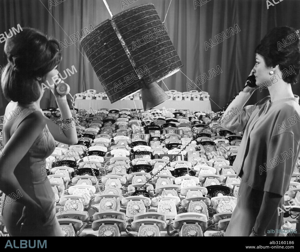 Los Angeles, California: April, 1965 Hughes Aircraft Company employees use two of the 480 telephones that the Intelsat 1 'Early Bird' communications satellite can transmit in two way telephone conversations between Europe and North America.