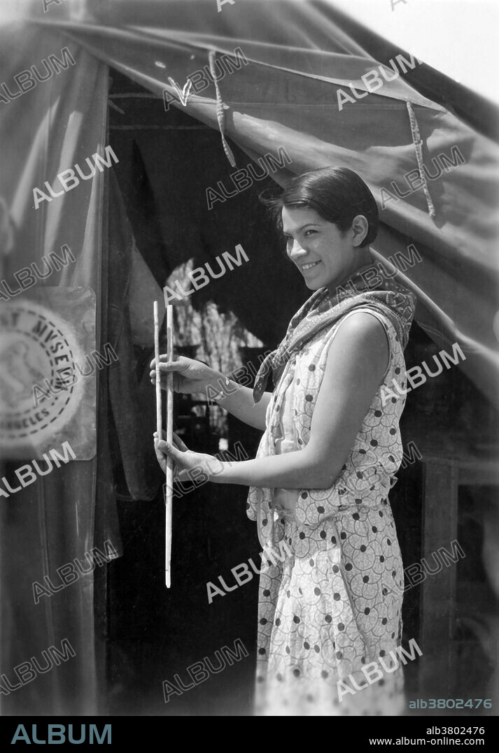 Bertha Pallan showing difference in size of early type (small) and late type atlatl darts (throwing sticks) from Gypsum Cave. Bertha "Birdie" Parker Pallan [Cody] (1907-1978) was the first American Indian female archaeologist, of Abenaki and Seneca descent. She participated in excavations at the site of Mesa House, and it may have been on the 1929 expedition that she discovered the pueblo site of Scorpion Hill while walking with her young daughter. She excavated the site herself, taking notes, photos, and later publishing the results; the finds were exhibited in the Southwest Museum. She worked at Gypsum Cave in 1930, a site that Harrington had claimed to have the earliest evidence for human occupation of North America during the Pleistocene.