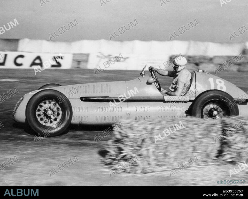 Luigi Villoresi winning the British Grand Prix, Silverstone, October 1948. Driving a Maserati 4CLT/48. Villoresi had been racing since the early 1930s. As a member of the Maserati team he twice won the Italian championship. In 1948 he switched to Ferrari, and then then joined Lancia in the early 1950s .